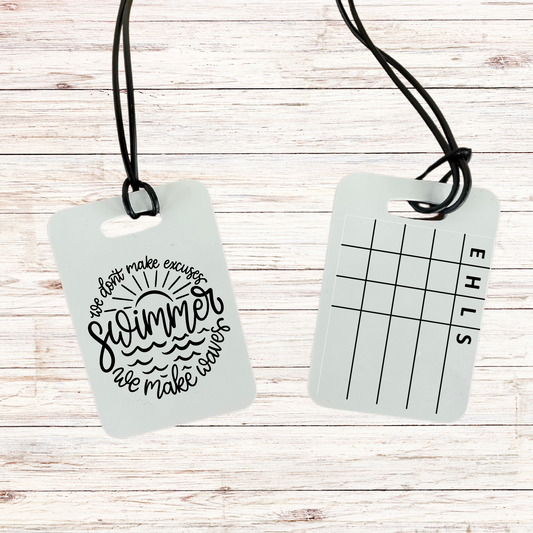 A reusable swim meet heat tag featuring "We Don't Make Excuses," designed to track event, heat, and lane assignments without arm-marking. A must-have tool for swim parents and competitive swimmers.
