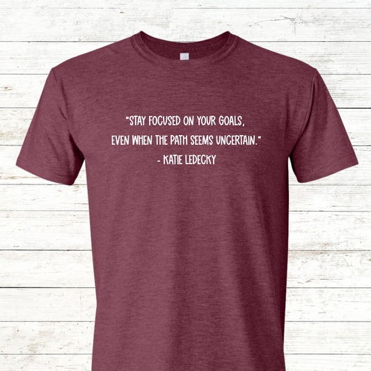 "Stay Focused on Your Goals" Quote by Katie Ledecky – Inspirational Apparel for Athletes – Available in Shirt, Sweatshirt & Hoodie. Motivational design featuring Katie Ledecky's powerful quote: "Stay Focused on Your Goals, Even When the Path Seems Uncertain." Perfect for swimmers, coaches, and anyone committed to achieving their goals. Available in multiple sizes and styles for a comfortable, inspiring fit.