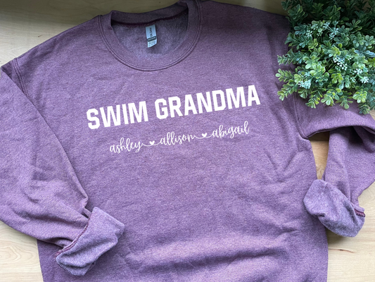 Personalized Swim Grandma Sweatshirt with your grandkid swimmer’s name, perfect for proud swim grandmas who want to show off their support at swim meets. Made from a soft, cozy fabric, this sweatshirt is designed for comfort and style while cheering on the next generation of swimmers. Add your grandkid’s name for a unique touch that makes it a special gift for any swim-loving grandma.